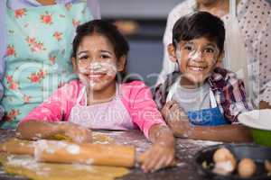 Portrait of smiling siblings with flour on face at home
