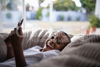 Portrait of cheerful boy using mobile at home