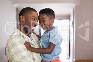 Father and son looking at each other in living room