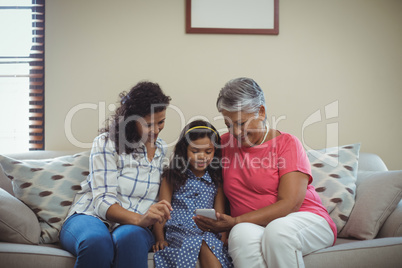 Happy family using mobile phone in living room