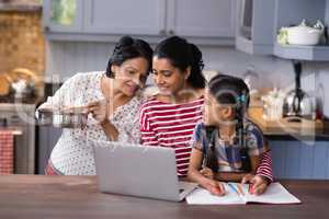 Multi-generation family using laptop in kitchen