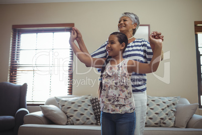 Grandmother and granddaughter having fun in living room