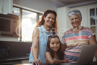 Happy family using laptop in kitchen