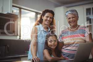 Happy family using laptop in kitchen