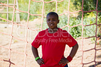 Boy standing with hands on hip during obstacle course training