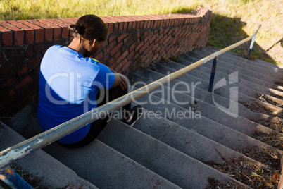 Upset woman sitting on staircase in the boot camp