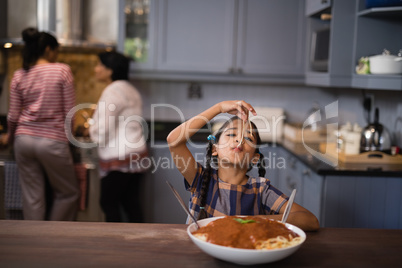 Girl eating spaghetti in kitchen