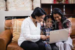 Happy multi-generation family using laptop together at home
