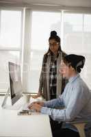 Executives discussing over computer in office