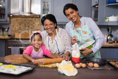 Smiling multi-generation family preparing food in kitchen