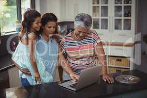 Happy family using laptop in kitchen