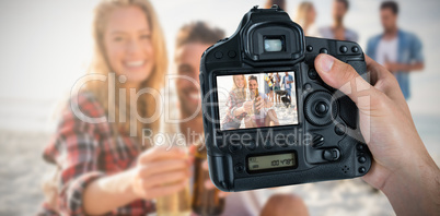 Composite image of cropped hand of photographer holding camera