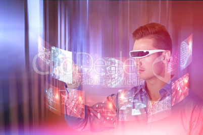 Composite image of young man pointing while using virtual video glasses