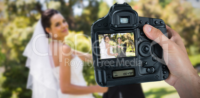 Composite image of cropped hand of photographer holding camera