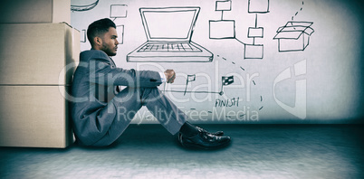 Composite image of businessman leaning on cardboard boxes against white background