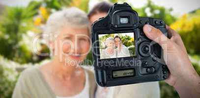 Composite image of cropped hand of photographer holding camera