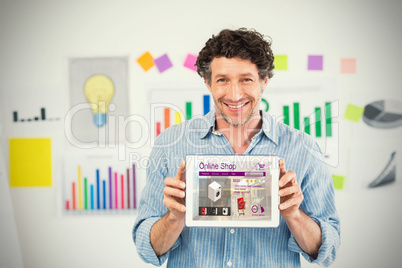 Composite image of businessman showing digital tablet with blank screen in creative office