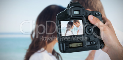 Composite image of cropped hand of photographer holding camera