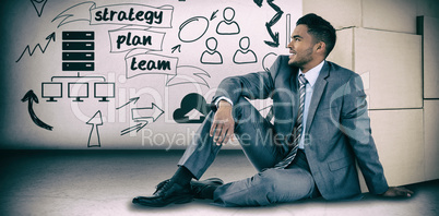 Composite image of businessman sitting near cardboard boxes against white background