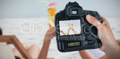 Composite image of cropped hand of photographer holding camera