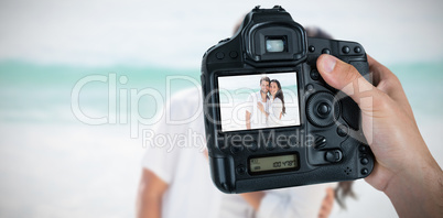 Composite image of cropped hand of photographer holding camera