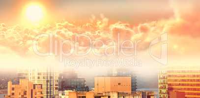 Composite image of scenic view of bright orange sun over cloudscape during sunset