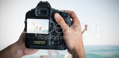 Composite image of cropped image of hands holding camera