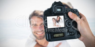 Composite image of cropped hand of photographer holding camera