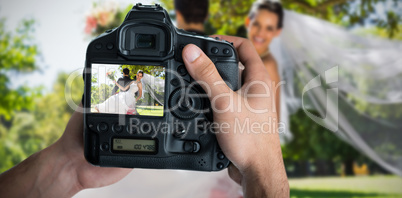 Composite image of cropped image of hands holding camera