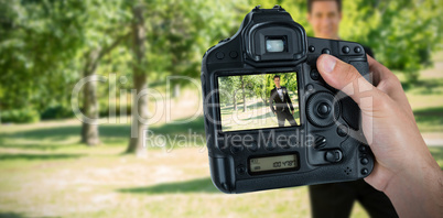 Composite image of cropped hand of photographer holding camera