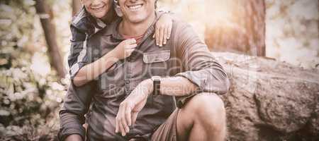 Smiling father and son hiking in forest