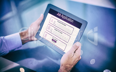 Composite image of businessman using his tablet