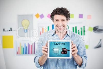 Composite image of businessman showing digital tablet with blank screen in creative office