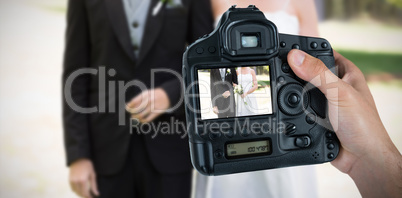 Composite image of cropped hand of photographer holding camera