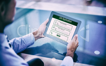 Composite image of businessman using his tablet