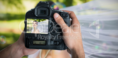 Composite image of cropped image of hands holding camera