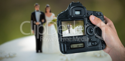 Composite image of cropped hand of photographer holding camera