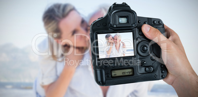 Composite image of cropped hand of photographer holding camera