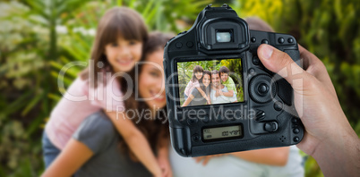 Composite image of cropped hand of photographer holding camera