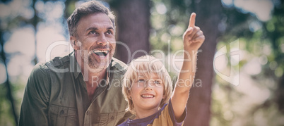 Boy showing something to father while hiking in forest