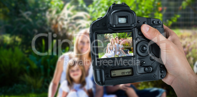 Composite image of cropped hand of photographer holding camera