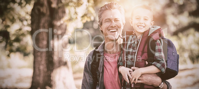 Portrait of happy father and son in forest