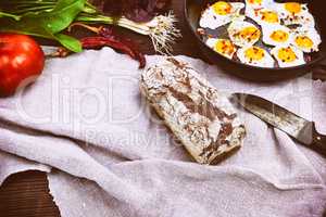 loaf of rye bread and fried eggs in a black frying pan