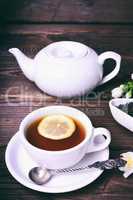 Cup of tea with lemon on a brown wooden background