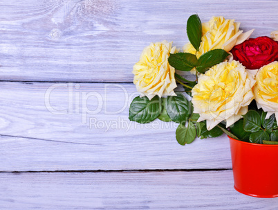 Bouquet of blossoming roses in an orange bucket