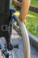 Hand of young man on the wheel of wheelchair