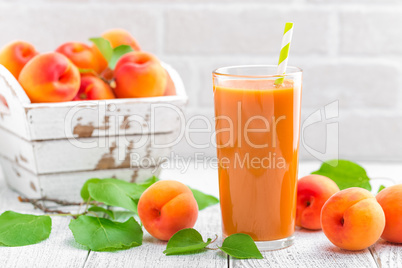 Apricot juice and fresh fruits with leaves