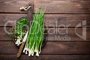 Green onion or scallion on wooden board, fresh spring chives