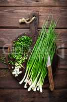 Green onion or scallion on wooden board, fresh spring chives