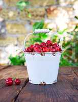 Red ripe cherry in a white iron bucket